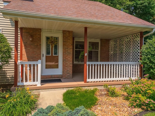 2321 Woodhavens Dr, Bloomington, IL 61701 - entrance to property featuring a porch, roof with shingles, and brick siding
