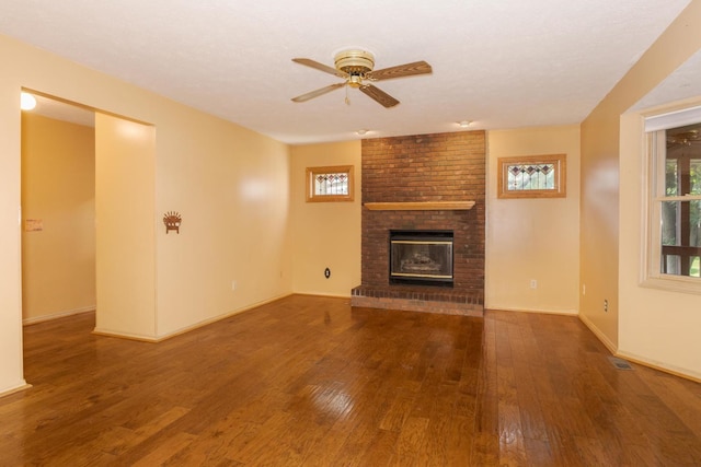 2321 Woodhavens Dr, Bloomington, IL 61701 - unfurnished living room with a brick fireplace, wood-type flooring, and plenty of natural light