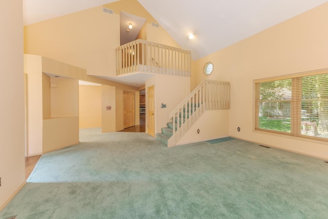 2321 Woodhavens Dr, Bloomington, IL 61701 - unfurnished living room featuring high vaulted ceiling, stairway, and carpet