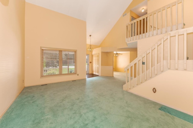 2321 Woodhavens Dr, Bloomington, IL 61701 - unfurnished living room with high vaulted ceiling, stairway, carpet flooring, and ceiling fan