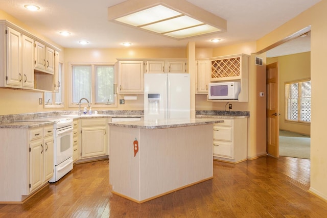 2321 Woodhavens Dr, Bloomington, IL 61701 - kitchen with white appliances, a kitchen island, wood finished floors, recessed lighting, and light stone countertops