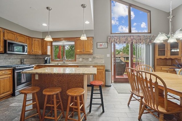16212 Forest Ave, Oak Forest, IL 60452 - kitchen featuring stainless steel appliances, backsplash, a center island, a sink, and a kitchen bar