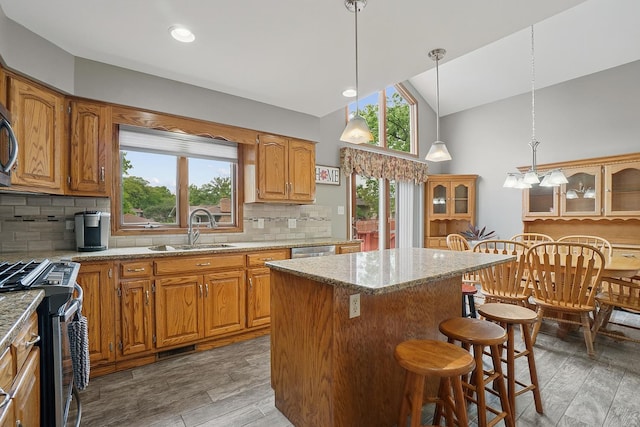 16212 Forest Ave, Oak Forest, IL 60452 - kitchen featuring a sink, stainless steel appliances, tasteful backsplash, a kitchen island, and a kitchen bar