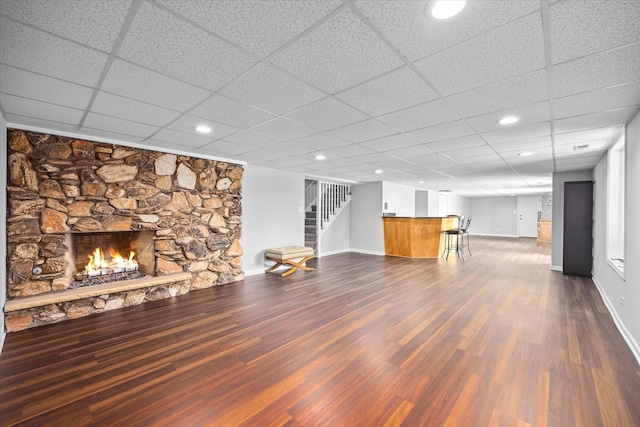 7 Surrey Rd, Lemont, IL 60439 - unfurnished living room with dark wood finished floors, baseboards, a fireplace, stairs, and a drop ceiling