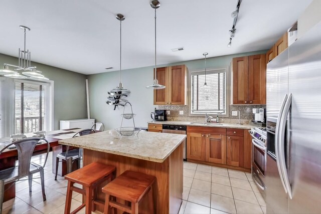 3159 W Washington Blvd, Chicago, IL 60612 - kitchen featuring stainless steel appliances, brown cabinets, a sink, and light tile patterned flooring