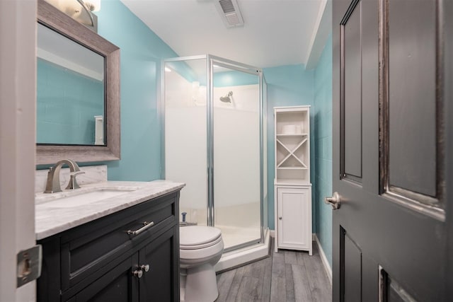 817 N Mohave Dr, Pontiac, IL 61764 - bathroom featuring wood finished floors, toilet, a stall shower, and vanity
