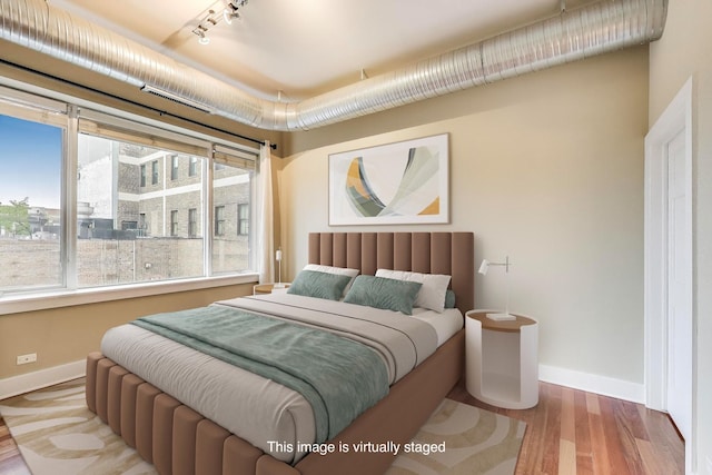 4751 N Artesian Ave Unit 206, Chicago, IL 60625 - bedroom featuring multiple windows, baseboards, and wood finished floors