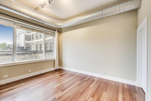 4751 N Artesian Ave Unit 206, Chicago, IL 60625 - spare room with wood finished floors, rail lighting, and baseboards