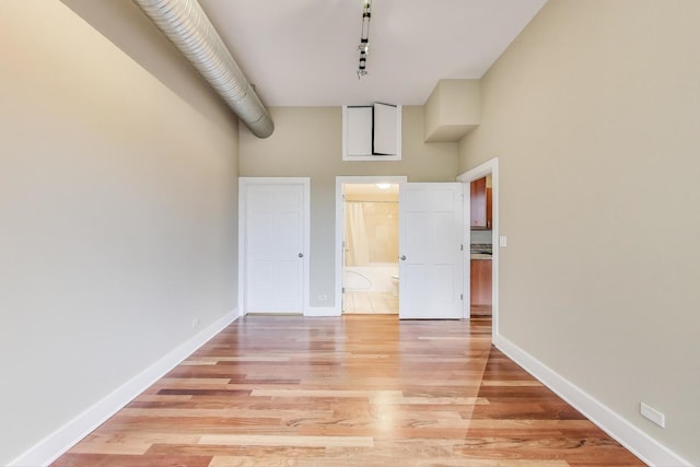 4751 N Artesian Ave Unit 206, Chicago, IL 60625 - unfurnished bedroom featuring a high ceiling, light wood finished floors, baseboards, and ensuite bath