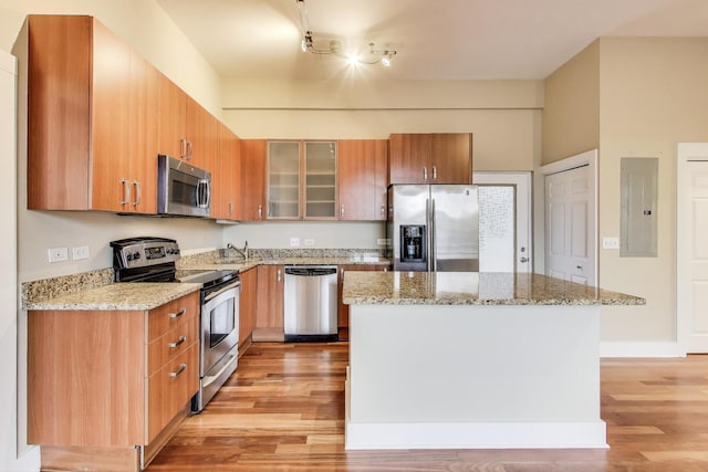 4751 N Artesian Ave Unit 206, Chicago, IL 60625 - kitchen featuring appliances with stainless steel finishes, electric panel, light wood finished floors, a sink, and glass insert cabinets