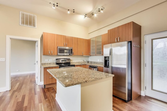 4751 N Artesian Ave Unit 206, Chicago, IL 60625 - kitchen with stainless steel appliances, wood finished floors, light stone countertops, and brown cabinetry