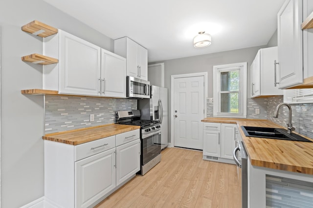 8837 S Morgan St, Chicago, IL 60620 - kitchen with wood counters, appliances with stainless steel finishes, a sink, open shelves, and light wood-style floors