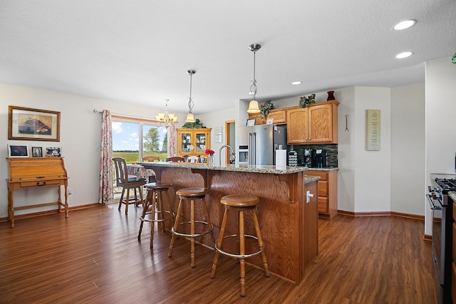 2609 E 1500s Rd, Kankakee, IL 60901 - kitchen featuring appliances with stainless steel finishes, dark wood-style flooring, a breakfast bar area, baseboards, and recessed lighting