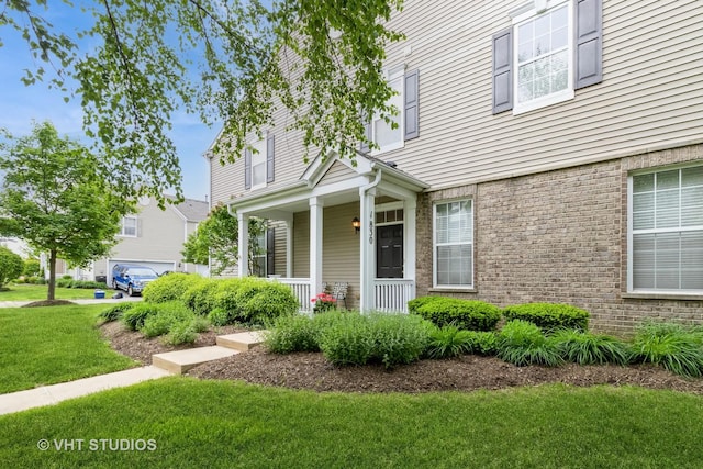 1830 Powers Rd, Woodstock, IL 60098 - view of exterior entry featuring a porch and a lawn