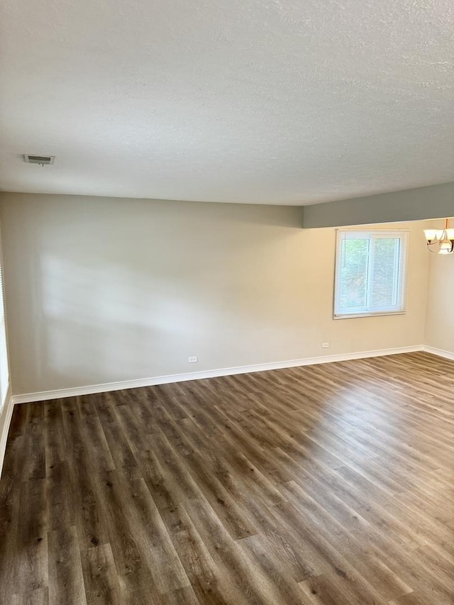 716 Shining Water Dr, Carol Stream, IL 60188 - empty room with dark wood-type flooring, a chandelier, and a textured ceiling