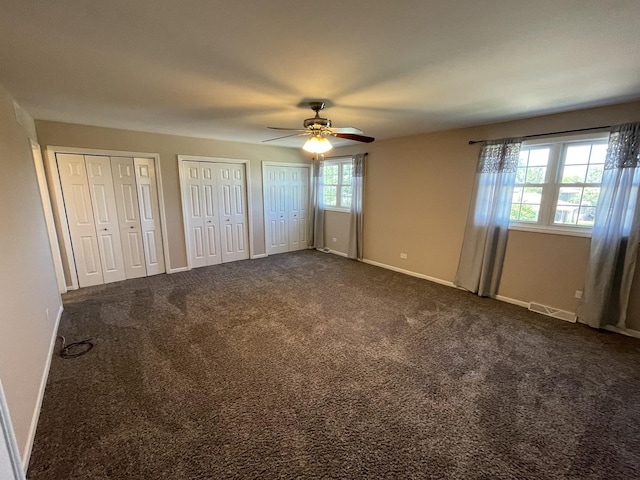 13153 W Pin Oak Dr, Homer Glen, IL 60491 - unfurnished bedroom with two closets, baseboards, dark carpet, and ceiling fan