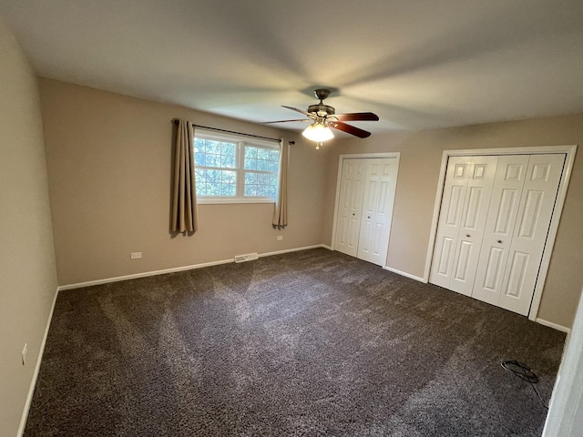13153 W Pin Oak Dr, Homer Glen, IL 60491 - unfurnished bedroom with multiple closets, dark carpet, ceiling fan, and baseboards