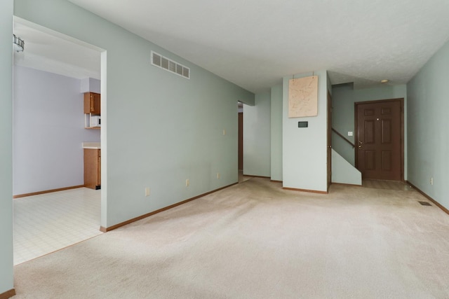 1560 Hunt Dr Unit A, Normal, IL 61761 - empty room featuring light carpet, baseboards, and stairs
