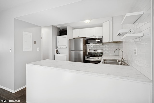 852 Oxford Pl Unit 852, Wheeling, IL 60090 - kitchen with stainless steel appliances, a sink, open shelves, stacked washing machine and dryer, and a peninsula