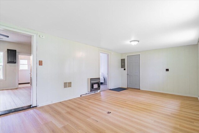 323 N 2nd Ave, Chenoa, IL 61726 - unfurnished living room featuring wood finished floors, heating unit, baseboards, and electric panel