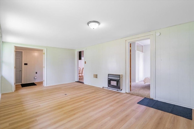 323 N 2nd Ave, Chenoa, IL 61726 - unfurnished living room featuring heating unit, wood finished floors, and a wood stove