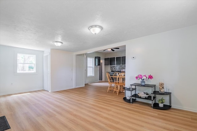 323 N 2nd Ave, Chenoa, IL 61726 - living room with healthy amount of natural light, a textured ceiling, light wood finished floors, and ceiling fan