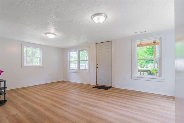 323 N 2nd Ave, Chenoa, IL 61726 - entryway featuring a textured ceiling, light wood-type flooring, and baseboards