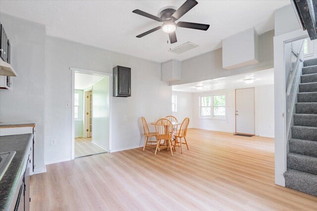 323 N 2nd Ave, Chenoa, IL 61726 - dining space with stairway, light wood-type flooring, ceiling fan, and baseboards