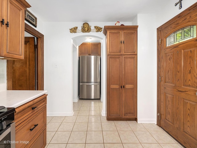 82 Northgate Rd, Riverside, IL 60546 - kitchen featuring stainless steel appliances, light countertops, arched walkways, and brown cabinets