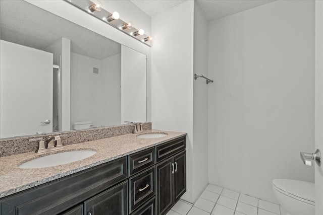 3120 S Indiana Ave Unit 207, Chicago, IL 60616 - bathroom featuring toilet, tile patterned flooring, double vanity, an enclosed shower, and a textured ceiling