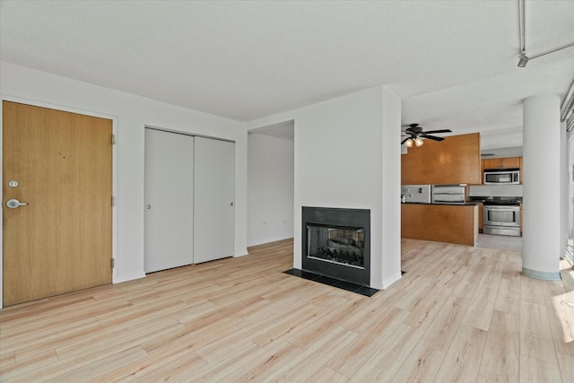 3120 S Indiana Ave Unit 207, Chicago, IL 60616 - unfurnished living room with light wood-type flooring, ceiling fan, and a multi sided fireplace