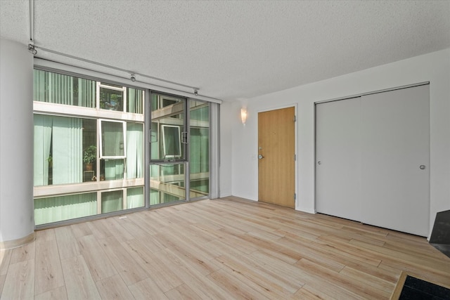 3120 S Indiana Ave Unit 207, Chicago, IL 60616 - unfurnished room featuring a textured ceiling, wood finished floors, and floor to ceiling windows