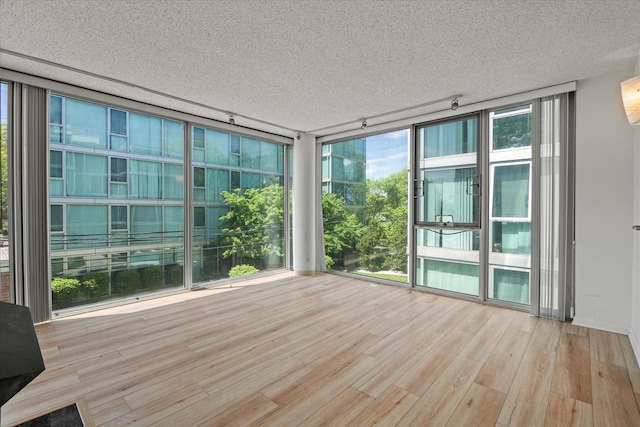 3120 S Indiana Ave Unit 207, Chicago, IL 60616 - unfurnished sunroom featuring a textured ceiling, wood finished floors, and a wall of windows