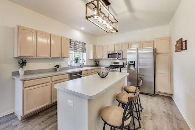 1400 Patrick Dr, Mundelein, IL 60060 - kitchen with appliances with stainless steel finishes, light brown cabinets, a breakfast bar, a sink, and light wood-style flooring