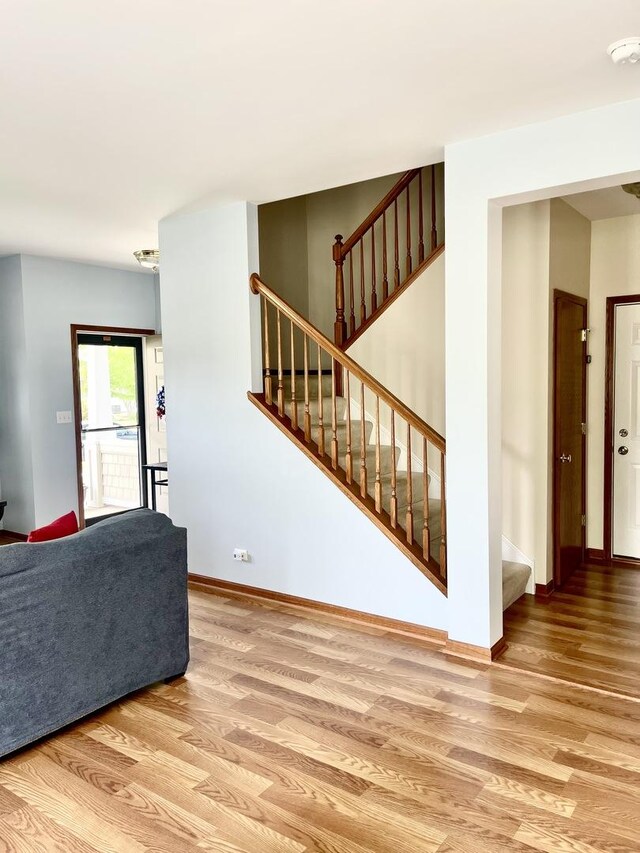 749 S Vintage Ln, Round Lake, IL 60073 - unfurnished living room with wood finished floors, stairs, and baseboards