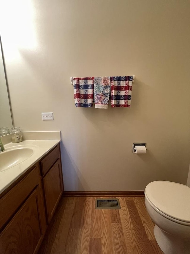 749 S Vintage Ln, Round Lake, IL 60073 - half bathroom featuring vanity, wood finished floors, toilet, and baseboards