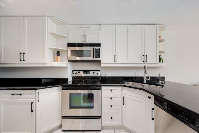 1221 N Dearborn St Unit 601S, Chicago, IL 60610 - kitchen featuring open shelves, appliances with stainless steel finishes, a sink, white cabinets, and light tile patterned floors