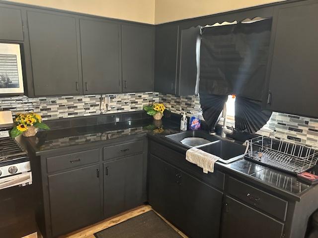746 May St, Calumet City, IL 60409 - kitchen with a sink, decorative backsplash, and dark countertops