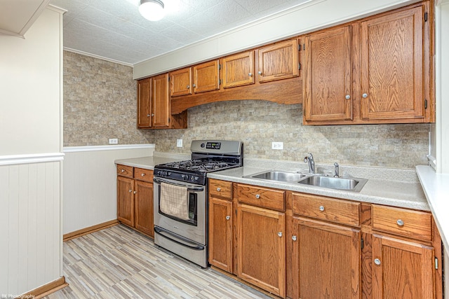 4243 W 90th Pl, Hometown, IL 60456 - kitchen with gas stove, brown cabinets, light wood finished floors, light countertops, and wainscoting