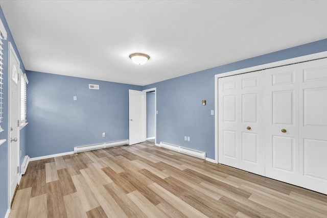 713 E Michigan Ave, Urbana, IL 61801 - unfurnished bedroom with a baseboard radiator, light wood-type flooring, baseboards, and a closet