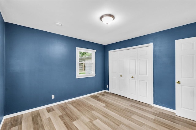 713 E Michigan Ave, Urbana, IL 61801 - unfurnished bedroom featuring wood finished floors, a closet, and baseboards