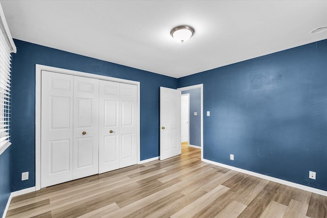 713 E Michigan Ave, Urbana, IL 61801 - unfurnished bedroom with wood finished floors, baseboards, and a closet