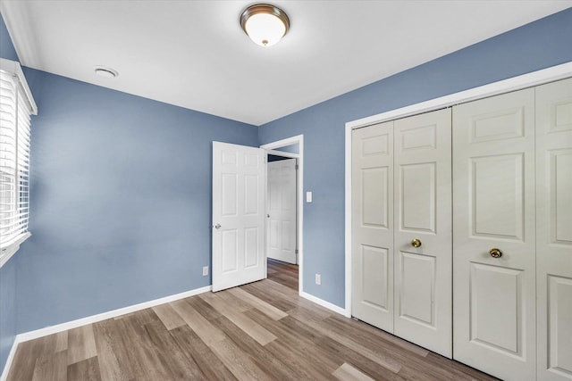 713 E Michigan Ave, Urbana, IL 61801 - unfurnished bedroom with wood finished floors, baseboards, and a closet