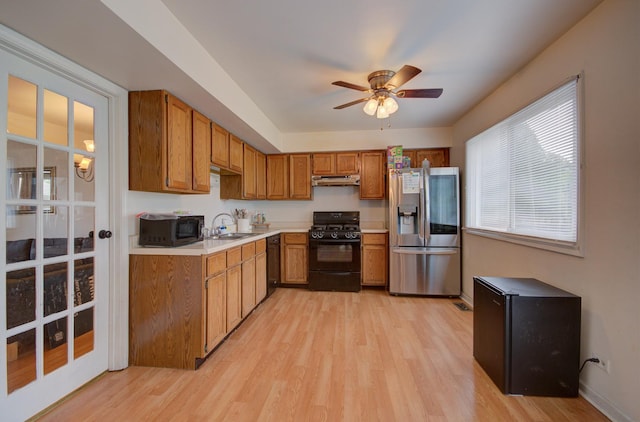 649 Sundance Dr, Bolingbrook, IL 60440 - kitchen featuring black appliances, a sink, under cabinet range hood, light wood-style floors, and light countertops