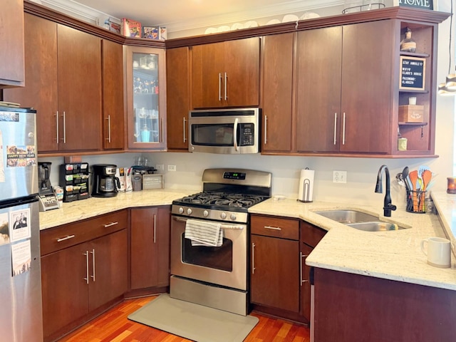 4950 N Western Ave Unit Ph2, Chicago, IL 60625 - kitchen with appliances with stainless steel finishes, a sink, light wood-style flooring, light stone countertops, and crown molding