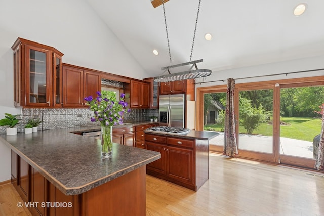 4335 Dewey Ave, Matteson, IL 60443 - kitchen featuring appliances with stainless steel finishes, dark countertops, decorative backsplash, light wood finished floors, and high vaulted ceiling
