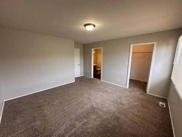 5911 Timberlane Rd, Matteson, IL 60443 - unfurnished bedroom with dark colored carpet, a spacious closet, baseboards, connected bathroom, and a closet
