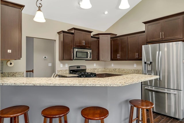 1200 Farmstone Dr, Diamond, IL 60416 - kitchen featuring appliances with stainless steel finishes, dark brown cabinetry, vaulted ceiling, dark wood-style flooring, and a peninsula