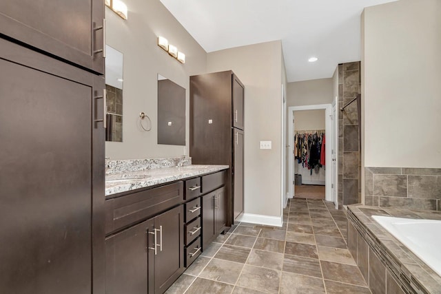 1200 Farmstone Dr, Diamond, IL 60416 - bathroom with double vanity, a bath, baseboards, a spacious closet, and tiled shower