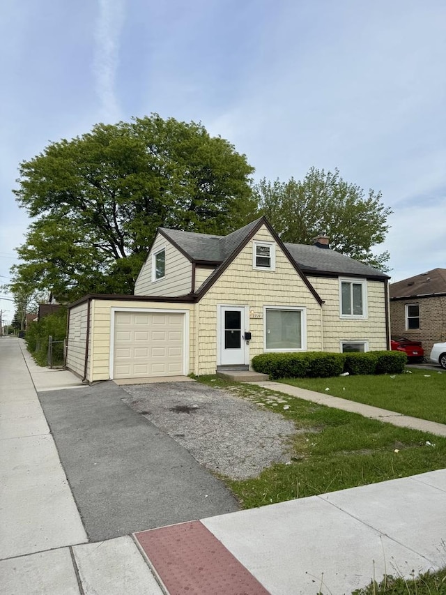 2219 S 13th Ave, Broadview, IL 60155 - view of front of house with driveway, a chimney, a garage, and a front lawn